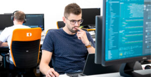 Programista pracuje przed komputerem